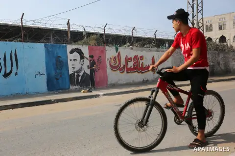 A Palestinian artist paints an anti-French President Emmanuel Macron mural to protest against the publications of a cartoon of Prophet Mohammad in France and Macron's comments, in the Nusseirat refugee camp in the centra...