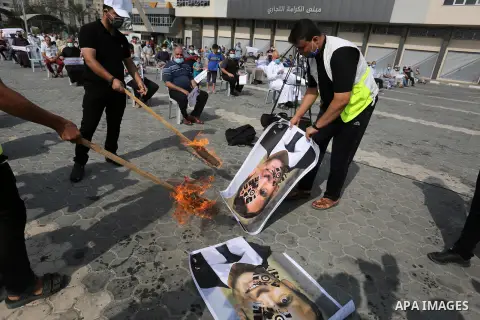 Palestinian Hamas supporters burn pictures depicting French President Emmanuel Macron during a protest against the publications of a cartoon of Prophet Mohammad in France and Macron's comments, in Khan Younis in the sout...