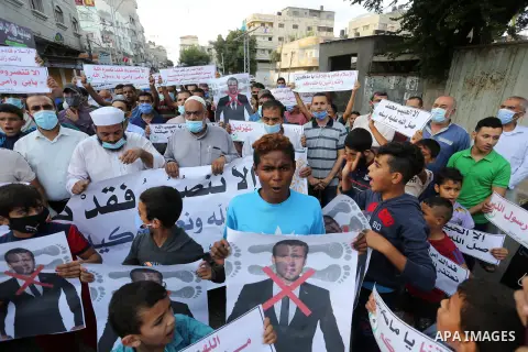 Palestinians take part in a protest against the publications of a cartoon of Prophet Mohammad in France and comments by French President Emmanuel Macron, in Dair Al Balah in the central of Gaza Strip on October 30, 2020....