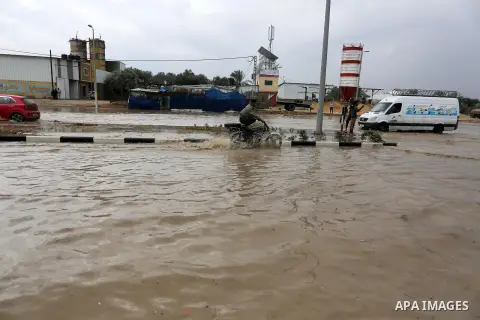 Palestinian workers work on a flooded street following a heavy rain, in Dair Al Balah in the central of Gaza Strip, on November 5, 2020. Photo by Ashraf Amra