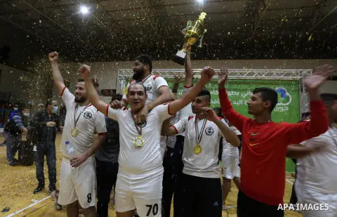 Palestinian handball players from the Etihad Deir Al-Balah (White) and khadamat Al-Bureij (Black) compete during the Cup Final in Saad Sayel gymnasium, in Gaza City on November 16, 2020. Photo by Ashraf Amra