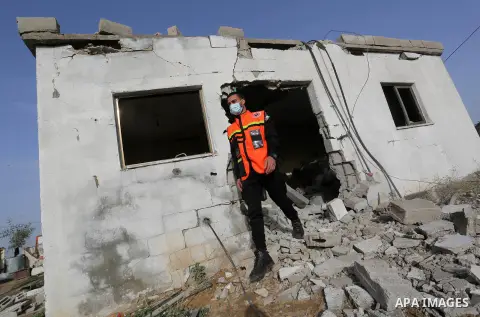 Palestinian Members of the civil defence inspect of a house following Israeli artillery shelling, in the east of Gaza City on December 15, 2020. Late last night, Israeli tanks bombed a Palestinian house in the Gaza Strip...