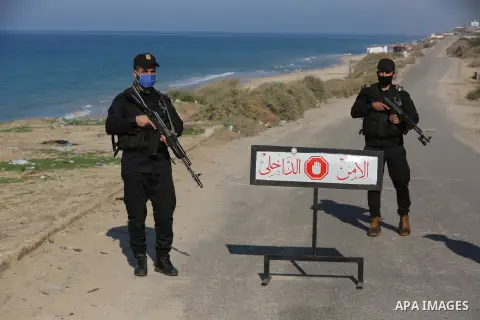 Palestinian policemen wear face masks, stand guard during a complete closure amid the spread of the Coronavirus COVID-19, in Deir al-Balah, central of Gaza Strip, on December 19, 2020, in the second week after the Minist...