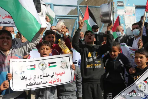 Palestinians wearing face masks, take part in a protest against the reduction of the food basket provided by the United Nations Relief and Works Agency for Palestine Refugees (UNRWA), in front of the UNRWA aid distributi...