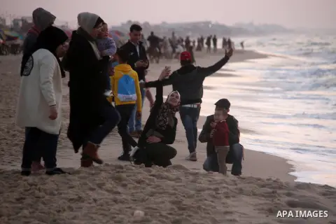 Palestinians enjoy their time on the beach during sunset in the last day of 2020, before the complete closure amid the spread of the Coronavirus COVID-19, in Gaza City on December 31, 2020, in the fourth week after the M...