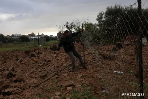 A Palestinian man inspects a land damaged in an Israeli air strike in Khan Younis in the southern Gaza Strip, on January 18, 2021. Palestinian sources said the air attacks early on Monday struck an agricultural field in...