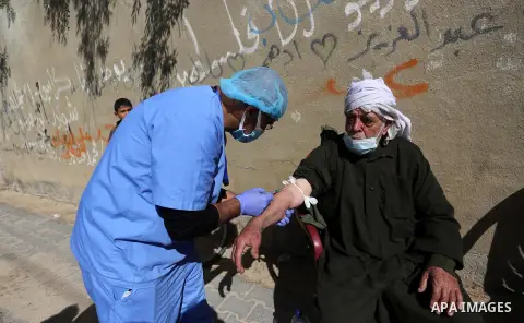 A Palestinian medical worker wearing protective gear, takes a random blood sample, in Deir al-Balah, central of Gaza Strip, on January 30, 2021. Safety and infection control teams at the Ministry of Health in the Gaza St...