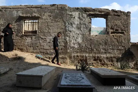 The mother and brother of Mohammad, one of the four children from the extended Bakr family who were killed during the 2014 Israeli-Palestinian conflict, visit the victim's grave in al-Shati refugee camp in Gaza City on F...