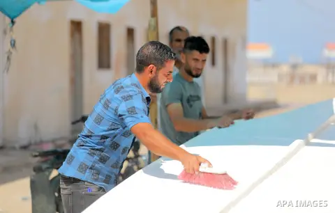 Palestinian maintain and repair the fishing boats using fiberglass material, at the Gaza seaport, on September 12, 2023. The boats began piling up in Gaza 15 years ago after Israel, imposed a land, air, and sea blockade...