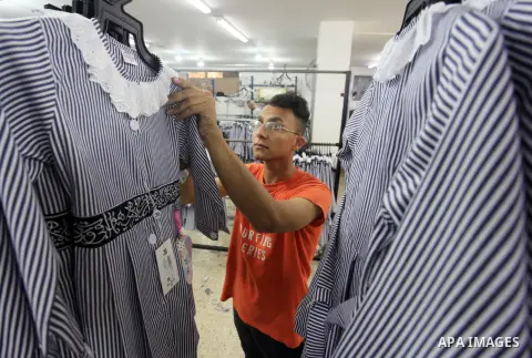 Palestinian workers sew the school uniform factory before the start of the new school year at a factory, in Gaza city, on August 06, 2023. Palestinian Ministry of Education announced the 29 August is the first day of new...
