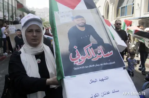 Palestinian protesters stand by mock coffins covered with the Palestinian flag as they demand the return of the bodies of their slain relatives held by Israeli forces, during a rally in Nablus city in the West Bank on Au...