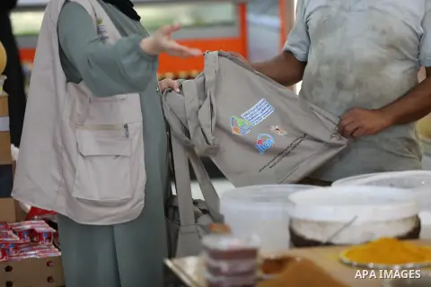 Palestinians distribute canvas bag to citizens as a youth initiative in the northern Gaza Strip on July 11, 2023. Within a youth initiative, Azhar Tanboura was able to implement the idea of replacing plastic bags with cl...