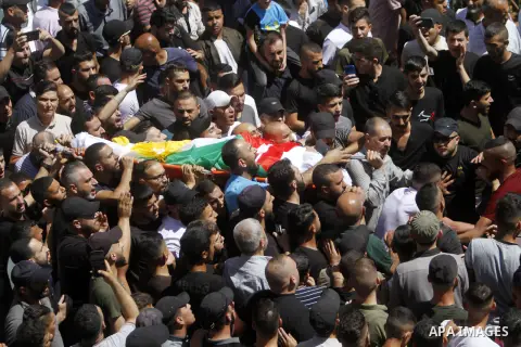Mourners carry the body of Palestinian Bader al-Masri, who was killed while the Israeli army was securing "the coordinated entrance of Israeli civilians to Joseph's Tomb", during the funeral in the city of Nablus in the...