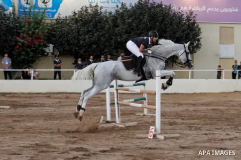 Palestinian competitors jump over a barrier during a local hurdles for horses championship, in Gaza city on July 21, 2023. Photo by Ali Hamad\ apaimages