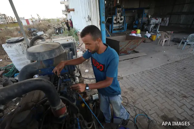 A Palestinian worker repairs and maintains olive pressing machines in Deir el-Balah, central Gaza Strip, on September 27, 2026, ahead of the olive harvest season. A number of olive presses were damaged by Israeli airstri...