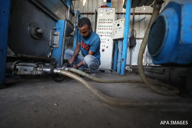A Palestinian worker repairs and maintains olive pressing machines in Deir el-Balah, central Gaza Strip, on September 27, 2026, ahead of the olive harvest season. A number of olive presses were damaged by Israeli airstri...