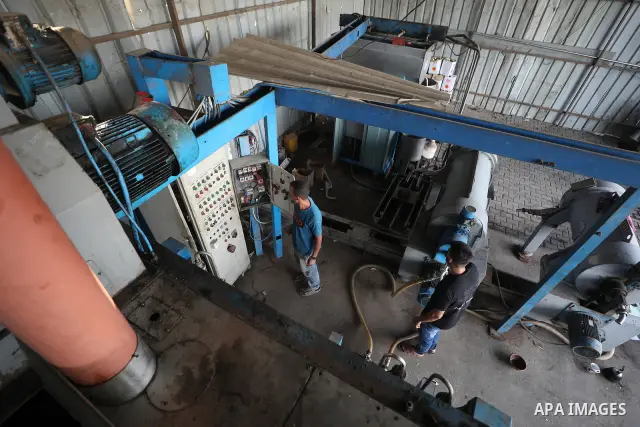A Palestinian worker repairs and maintains olive pressing machines in Deir el-Balah, central Gaza Strip, on September 27, 2026, ahead of the olive harvest season. A number of olive presses were damaged by Israeli airstri...