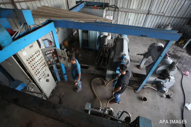 A Palestinian worker repairs and maintains olive pressing machines in Deir el-Balah, central Gaza Strip, on September 27, 2026, ahead of the olive harvest season. A number of olive presses were damaged by Israeli airstri...