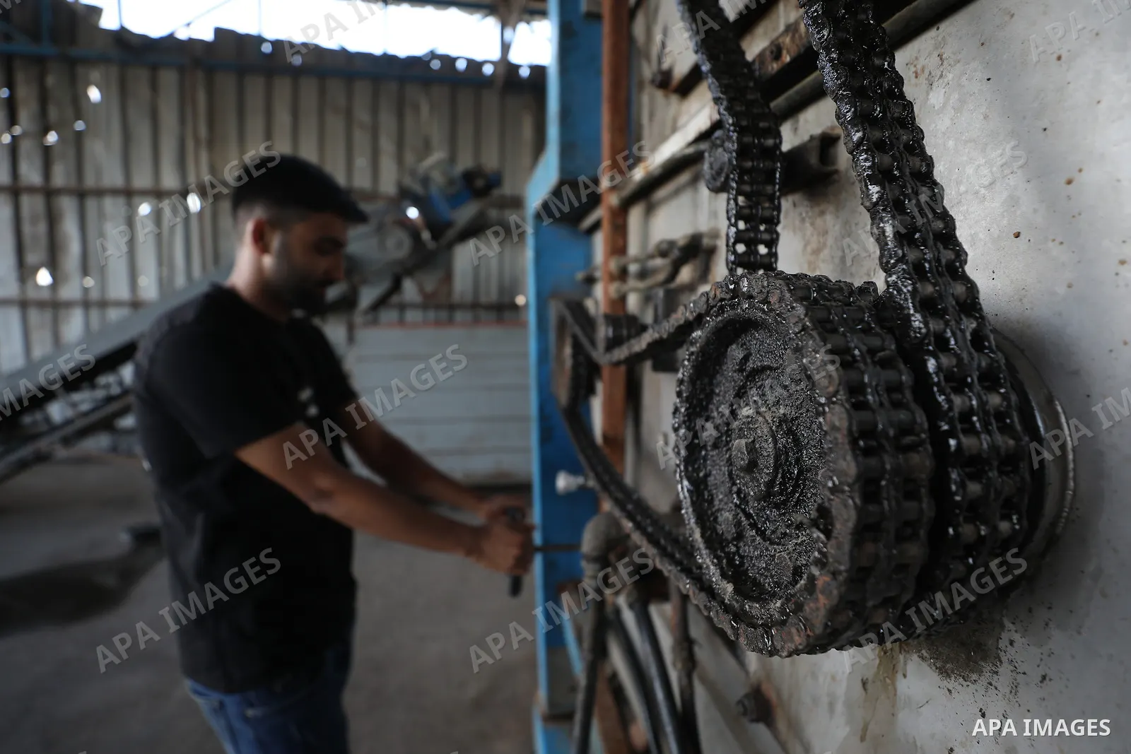 A Palestinian worker repairs and maintains olive pressing machines in Deir el-Balah, central Gaza Strip, on September 27, 2026, ahead of the olive harvest season. A number of olive presses were damaged by Israeli airstri...
