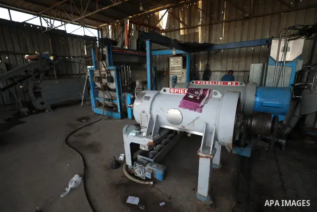 A Palestinian worker repairs and maintains olive pressing machines in Deir el-Balah, central Gaza Strip, on September 27, 2026, ahead of the olive harvest season. A number of olive presses were damaged by Israeli airstri...