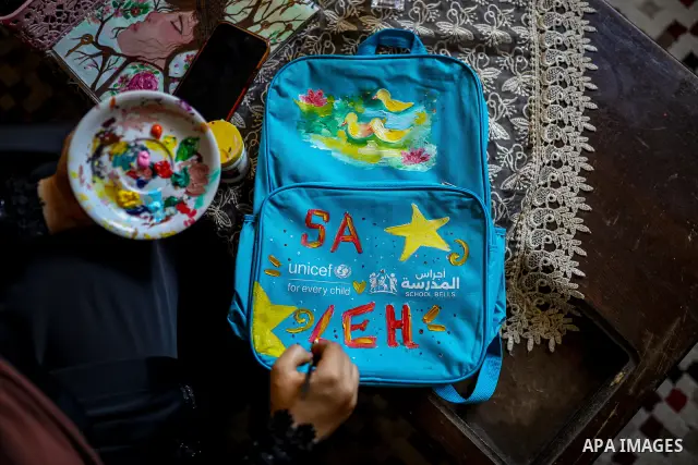 Palestinian visual artist Hala Abu Hamda, 18, paints and colors children’s bags inside her home in the al-Nasr neighborhood of Gaza City on September 27, 2026, as the new academic year begins. Students in the Gaza Strip...