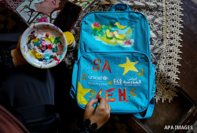 Palestinian visual artist Hala Abu Hamda, 18, paints and colors children’s bags inside her home in the al-Nasr neighborhood of Gaza City on September 27, 2026, as the new academic year begins. Students in the Gaza Strip...