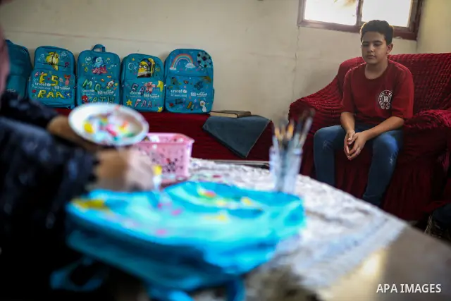 Palestinian visual artist Hala Abu Hamda, 18, paints and colors children’s bags inside her home in the al-Nasr neighborhood of Gaza City on September 27, 2026, as the new academic year begins. Students in the Gaza Strip...