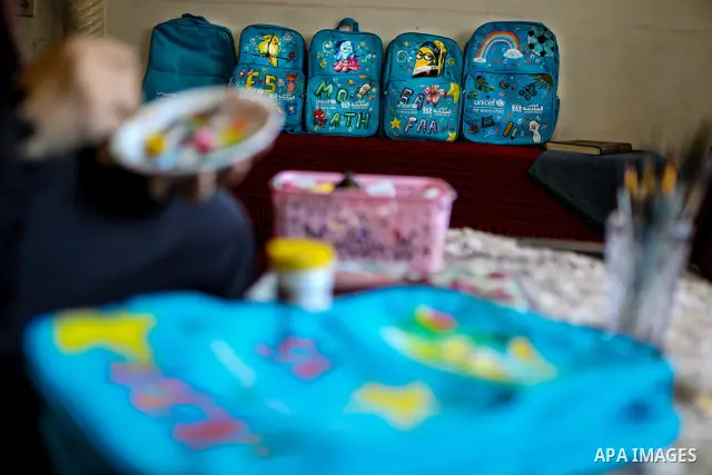Palestinian visual artist Hala Abu Hamda, 18, paints and colors children’s bags inside her home in the al-Nasr neighborhood of Gaza City on September 27, 2026, as the new academic year begins. Students in the Gaza Strip...