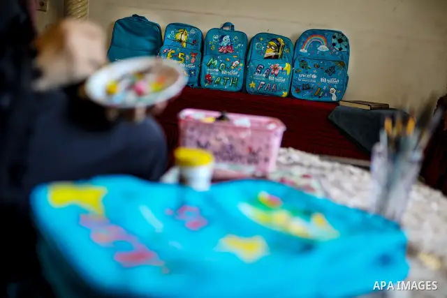 Palestinian visual artist Hala Abu Hamda, 18, paints and colors children’s bags inside her home in the al-Nasr neighborhood of Gaza City on September 27, 2026, as the new academic year begins. Students in the Gaza Strip...