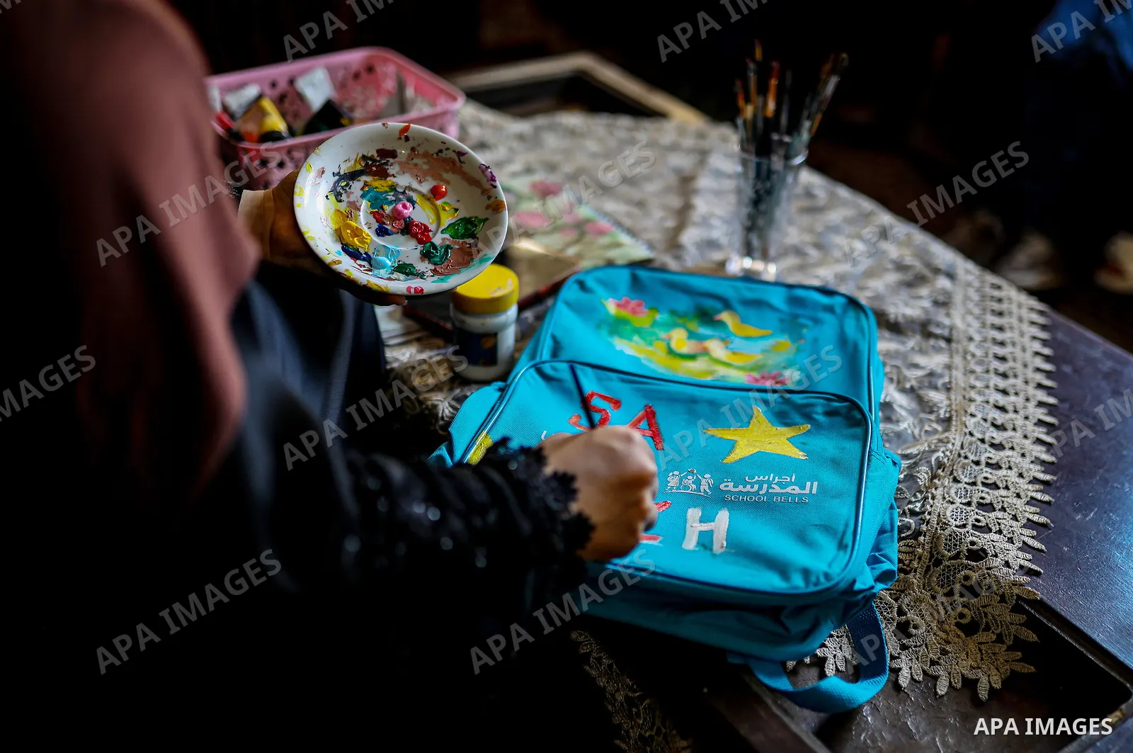 Palestinian visual artist Hala Abu Hamda, 18, paints and colors children’s bags inside her home in the al-Nasr neighborhood of Gaza City on September 27, 2026, as the new academic year begins. Students in the Gaza Strip...