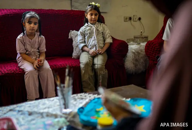 Palestinian visual artist Hala Abu Hamda, 18, paints and colors children’s bags inside her home in the al-Nasr neighborhood of Gaza City on September 27, 2026, as the new academic year begins. Students in the Gaza Strip...