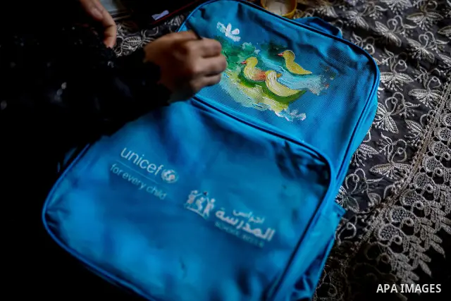 Palestinian visual artist Hala Abu Hamda, 18, paints and colors children’s bags inside her home in the al-Nasr neighborhood of Gaza City on September 27, 2026, as the new academic year begins. Students in the Gaza Strip...