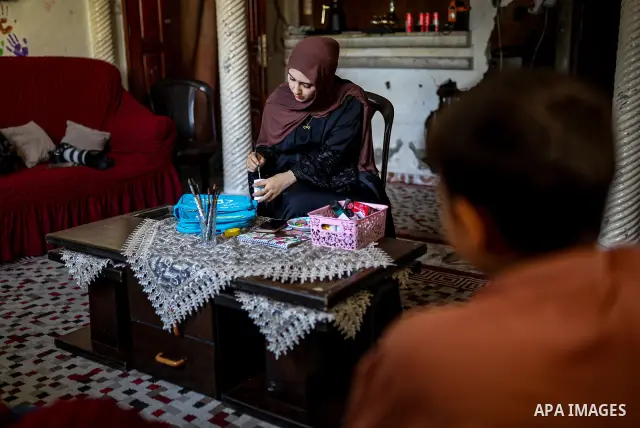 Palestinian visual artist Hala Abu Hamda, 18, paints and colors children’s bags inside her home in the al-Nasr neighborhood of Gaza City on September 27, 2026, as the new academic year begins. Students in the Gaza Strip...