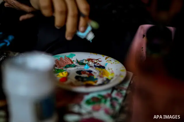 Palestinian visual artist Hala Abu Hamda, 18, paints and colors children’s bags inside her home in the al-Nasr neighborhood of Gaza City on September 27, 2026, as the new academic year begins. Students in the Gaza Strip...