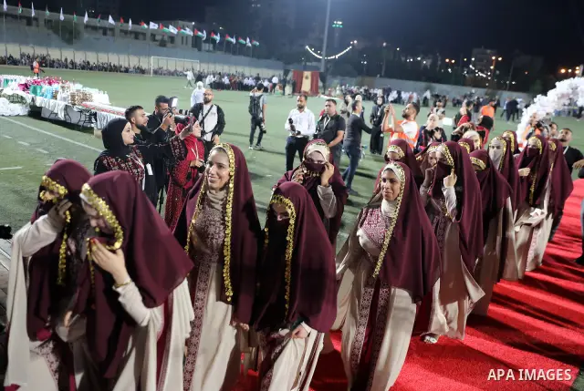 Brides and grooms take part in a mass wedding ceremony for 44 couples in Dura, near the West Bank city of Hebron, on September 26, 2026. Thousands of family members, residents and friends attended the celebration to mark...