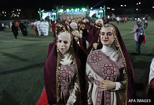 Brides and grooms take part in a mass wedding ceremony for 44 couples in Dura, near the West Bank city of Hebron, on September 26, 2026. Thousands of family members, residents and friends attended the celebration to mark...