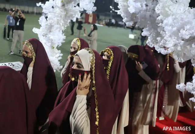 Brides and grooms take part in a mass wedding ceremony for 44 couples in Dura, near the West Bank city of Hebron, on September 26, 2026. Thousands of family members, residents and friends attended the celebration to mark...