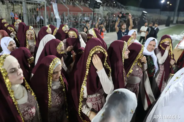 Brides and grooms take part in a mass wedding ceremony for 44 couples in Dura, near the West Bank city of Hebron, on September 26, 2026. Thousands of family members, residents and friends attended the celebration to mark...