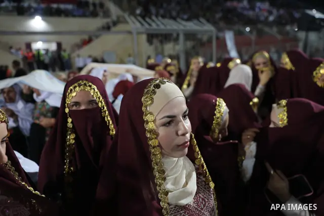 Brides and grooms take part in a mass wedding ceremony for 44 couples in Dura, near the West Bank city of Hebron, on September 26, 2026. Thousands of family members, residents and friends attended the celebration to mark...