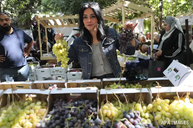 Palestinian farmers and residents take part in a grape festival in the Old City of Hebron, West Bank, on September 26, 2026, celebrating the grape harvest for which the area is known. The festival featured various grape...