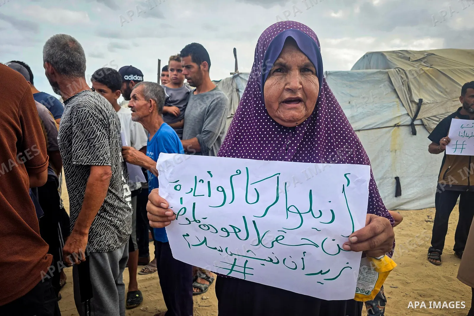 Displaced Palestinians bang on cooking pots during a protest at a cemetery in Khan Younis, southern Gaza Strip, on September 26, 2026, calling for improved living conditions in displacement tents as winter approaches. Th...