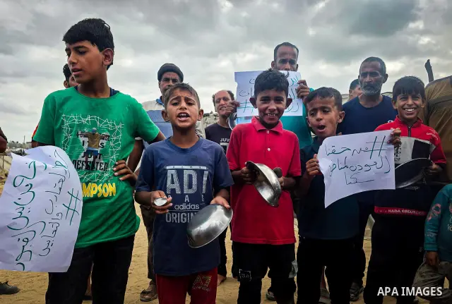 Displaced Palestinians bang on cooking pots during a protest at a cemetery in Khan Younis, southern Gaza Strip, on September 26, 2026, calling for improved living conditions in displacement tents as winter approaches. Th...