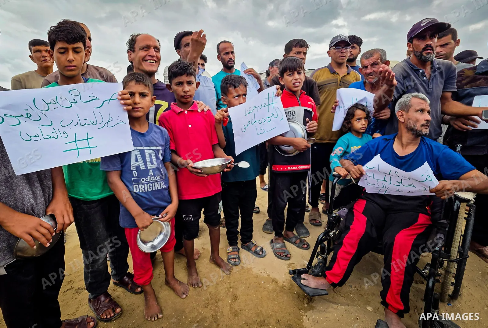 Displaced Palestinians bang on cooking pots during a protest at a cemetery in Khan Younis, southern Gaza Strip, on September 26, 2026, calling for improved living conditions in displacement tents as winter approaches. Th...
