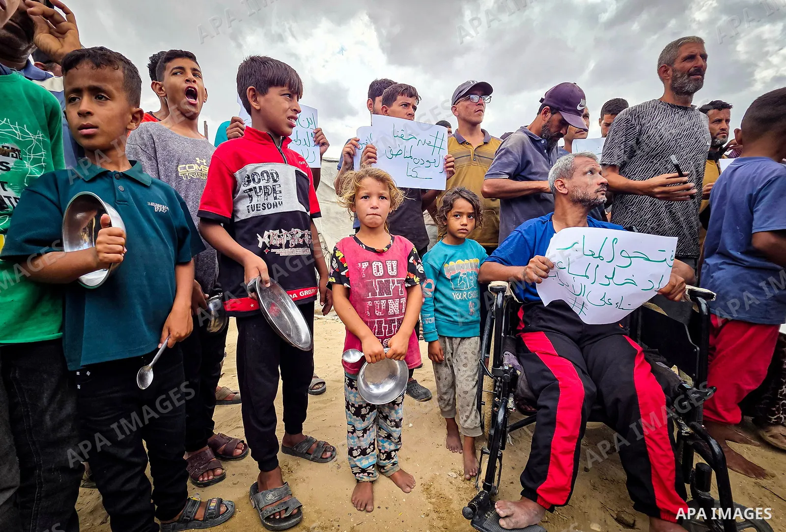 Displaced Palestinians bang on cooking pots during a protest at a cemetery in Khan Younis, southern Gaza Strip, on September 26, 2026, calling for improved living conditions in displacement tents as winter approaches. Th...