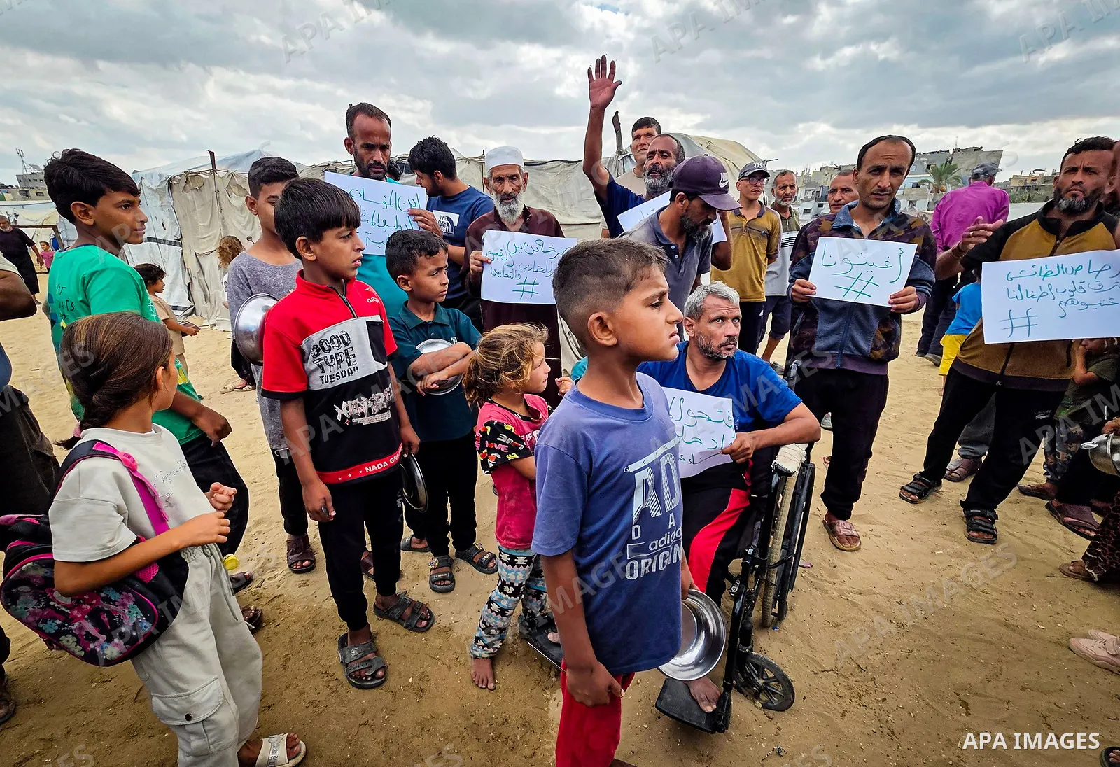 Displaced Palestinians bang on cooking pots during a protest at a cemetery in Khan Younis, southern Gaza Strip, on September 26, 2026, calling for improved living conditions in displacement tents as winter approaches. Th...