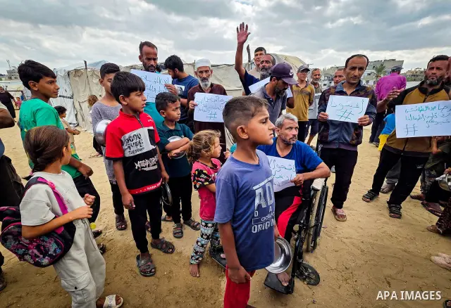 Displaced Palestinians bang on cooking pots during a protest at a cemetery in Khan Younis, southern Gaza Strip, on September 26, 2026, calling for improved living conditions in displacement tents as winter approaches. Th...