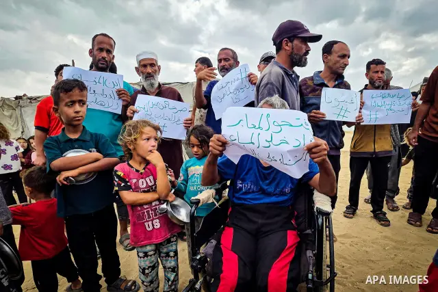 Displaced Palestinians bang on cooking pots during a protest at a cemetery in Khan Younis, southern Gaza Strip, on September 26, 2026, calling for improved living conditions in displacement tents as winter approaches. Th...