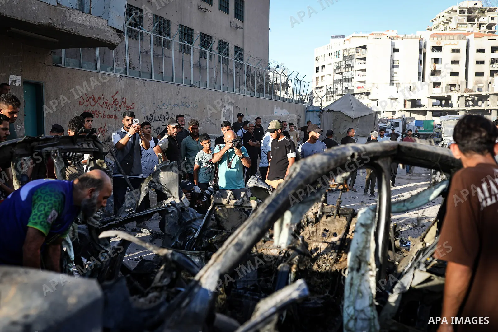 Palestinians gather at the site of an Israeli airstrike that targeted a vehicle near al-Sinaa junction in Gaza City on September 27, 2026. The strike killed one Palestinian and wounded others, according to local sources....
