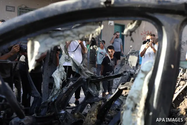 Palestinians gather at the site of an Israeli airstrike that targeted a vehicle near al-Sinaa junction in Gaza City on September 27, 2026. The strike killed one Palestinian and wounded others, according to local sources....