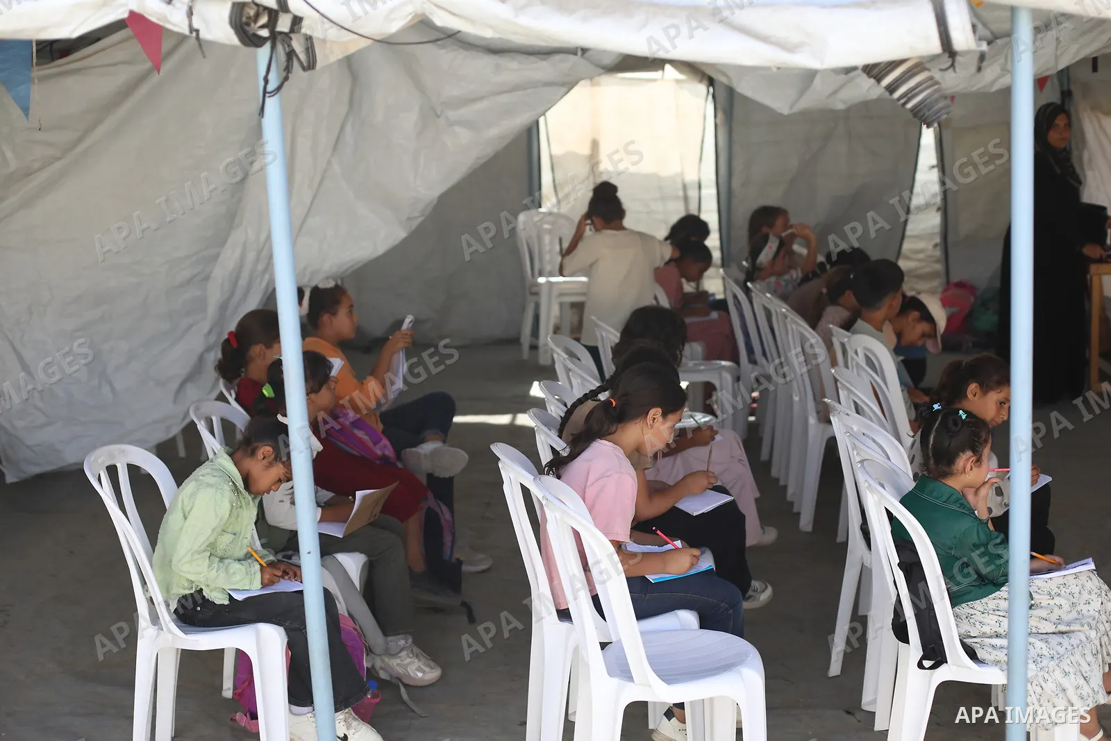 Palestinian students attend a lesson inside a tent in al-Bureij camp in the central Gaza Strip on September 26, 2026, as the new academic year resumes. Classes are being held amid widespread damage to schools and shortag...